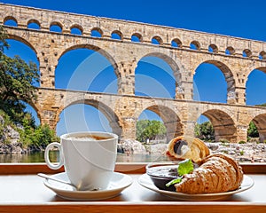 Coffee with croissants against Pont du Gard, is an old Roman aqueduct in Provence, France