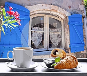 Coffee with croissants against window in Provence, France photo