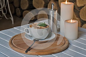 Coffee cup on bar table and romantic candles closeup