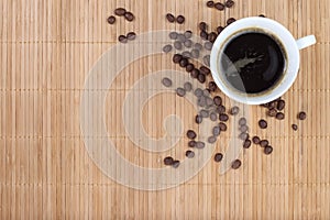 Coffee cup with beans on bamboo background