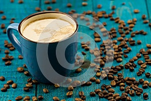 Coffee Cup and beans on blue wooden background