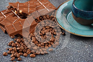 Coffee cup, beans, chocolate on old kitchen table