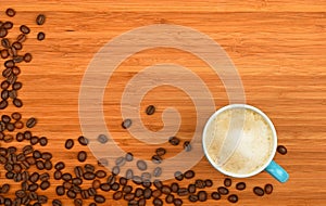 Coffee cup and beans over wood background