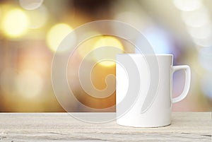 Coffee cup and beans on wood table over blurred tree background