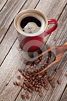 Coffee cup and beans on wooden table