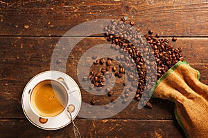 Coffee cup and beans on wooden table