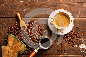 Coffee cup and beans on wooden table