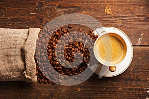 Coffee cup and beans on wooden table