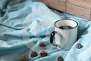 Coffee cup on a bed. Atmospheric hygge style. Good morning still life