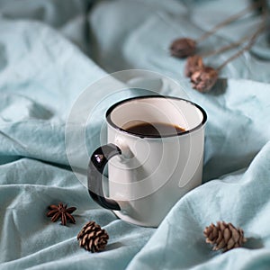 Coffee cup on a bed. Atmospheric hygge style. Good morning still life