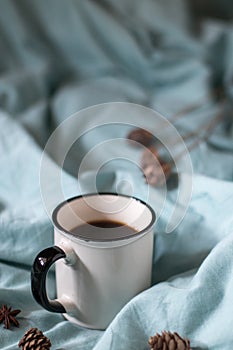 Coffee cup on a bed. Atmospheric hygge style. Good morning still life