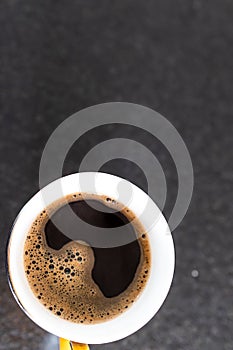 Coffee cup on black background. Top view. Coffee break during smart working at home. Black background