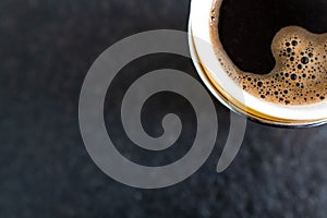 Coffee cup on black background. Top view. Coffee break during smart working at home. Black background