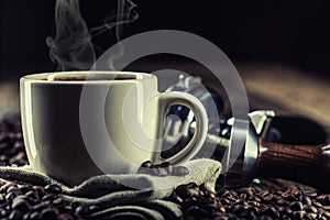 Coffee. Cup of black coffe with coffee beans tamper and portafilter photo