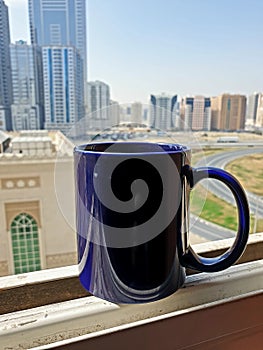Coffee cup in blue at city balcony