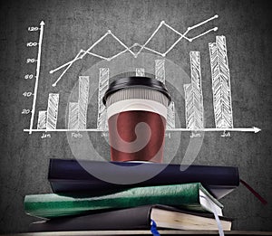 Coffee cup on books and drawing stock chart