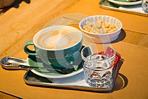 Coffee in a cup and bowl of nuts on a table