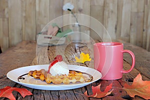 Coffee cup and breakfast  and autumn maple leaves are on a wooden table