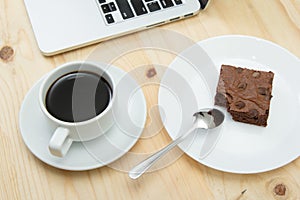 Coffee cup and brownie on wooden table