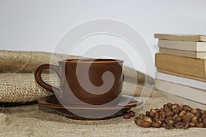 Coffee cup on burlac with book and blur background