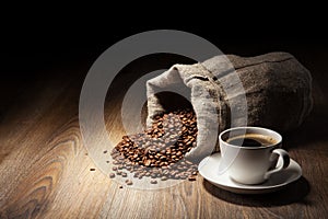 Coffee cup with burlap sack of roasted beans