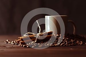 Coffee cup with burlap sack of roasted beans on rustic table