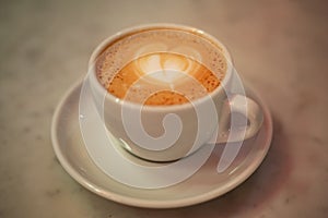 Coffee cup with cappuccino on old marble background. Soft focus shallow DOF vintage style  picture
