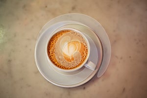 Coffee cup with cappuccino on old marble background. Soft focus shallow DOF vintage style  picture