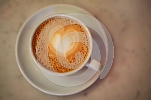 Coffee cup with cappuccino on old marble background. Soft focus shallow DOF vintage style  picture