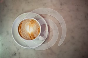 Coffee cup with cappuccino on old marble background. Soft focus shallow DOF vintage style  picture