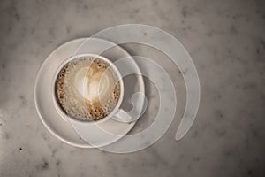 Coffee cup with cappuccino on old marble background. Soft focus shallow DOF vintage style  picture