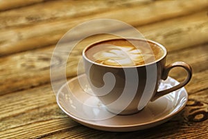 Coffee cup with cappuccino on old wooden background