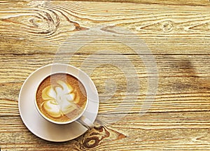 Coffee cup with cappuccino on old wooden background