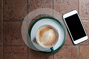 Coffee cup on ceramic table and mobile phone