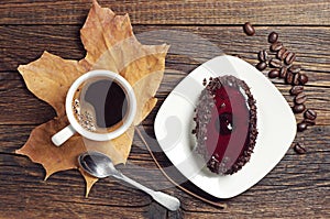 Coffee cup and chocolate cake with cherry jelly