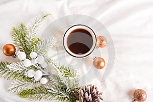 Coffee cup with Christmas decorations on white bed. Breakfast in bed. Winter morning