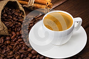 Coffee cup with cinamon on a wooden table.