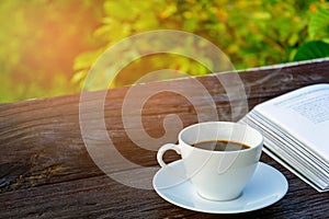 coffee cup clock and news paper on old wooden table