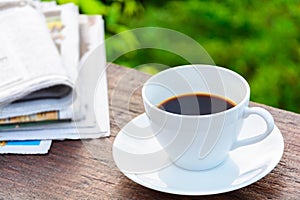 coffee cup clock and news paper on old wooden table