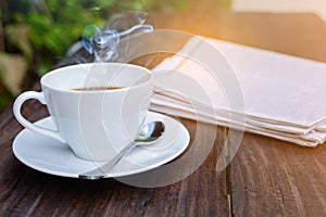 coffee cup clock and news paper on old wooden table nature background