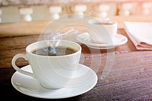 coffee cup clock and news paper on old wooden table nature background