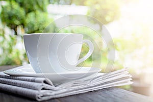 coffee cup clock and news paper on old wooden table nature background