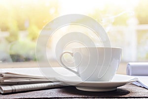 coffee cup clock and news paper on old wooden table nature background