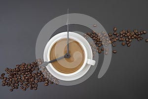 Coffee cup with clock tongues showing 8 o`clock isolated on black