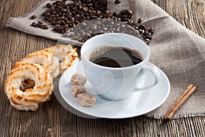 Coffee cup with coconut cookies, cinnamon and cane sugar