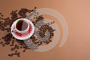 coffee cup and coffe beans mess on a brown background free space for text