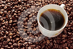 Coffee cup on coffee beans background.