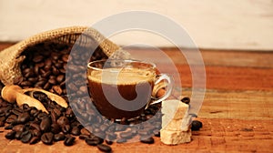 Coffee cup with Coffee beans, burlap sack and with cinnamon sticks