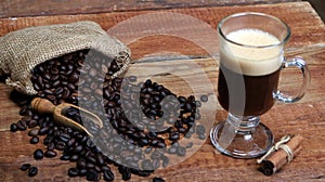 Coffee cup with Coffee beans, burlap sack and with cinnamon sticks