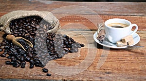 Coffee cup with Coffee beans, burlap sack and with cinnamon sticks